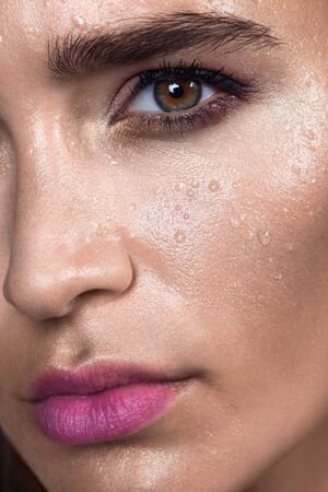 Close up gamour beauty woman portrait. Fashion wet shiny skin, with drops sexy gloss lips make-up and pink eyebrowsの写真素材