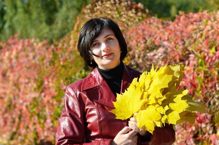 Beautiful woman with yellow leavesの写真素材
