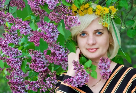 A beautiful woman  On his head a crown of flowers  lilac bushの写真素材