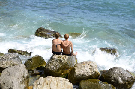 boy and girl sitting near the seaの写真素材