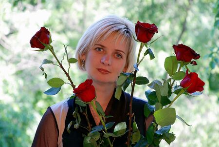 Beautiful woman holding a red roseの写真素材