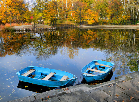 Two boats on the lake, pond. Autumn, water, landscape. Yellow leaves of the trees.の写真素材