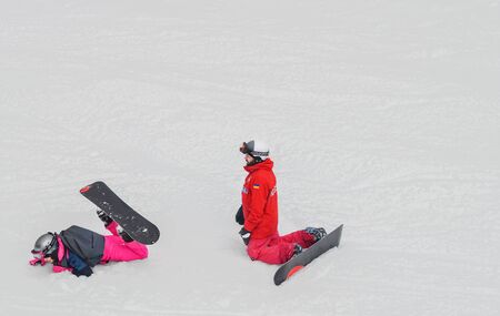Winter vacation, sport. People learn snowboarding. A fall.のeditorial素材