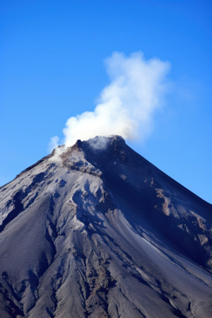 the awe-inspiring power and beauty of a towering volcano set against a clear blue sky..の素材