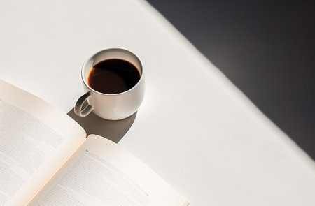 a cup of coffee sits next to a book full of pages.の素材