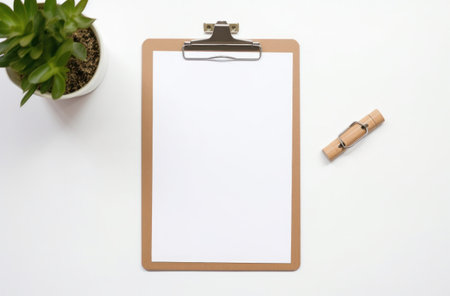 a clipboard with paper and accessories on top a white surface.の素材