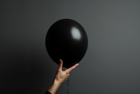 person pointing hands to a black balloonの素材
