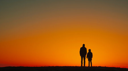 Minimalist image featuring a father and child silhouette against a sunset backdrop.の素材