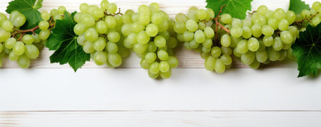 grapes hanging from a white wooden background with leaves.の素材