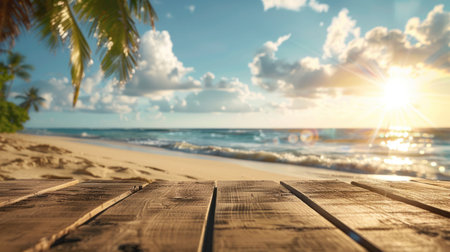 A tranquil tropical beach with fine sandy shores, a blurred sea, sunlit sky, and fluffy clouds in the background.の素材