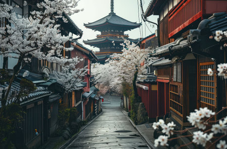 a narrow alley leading to a pagoda with white blossoms on either side.の素材