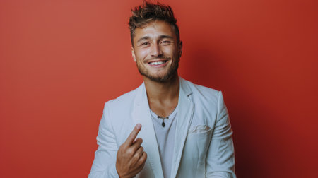 A man wearing a white suit standing and giving a thumbs up gesture.の素材