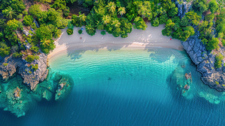 A birds eye view of a tropical beach with turquoise lagoon water, white sandy shores, and lush green palm trees.の素材