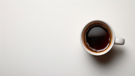 A cup of coffee rests on a clean white table, creating a simple and inviting scene.の素材