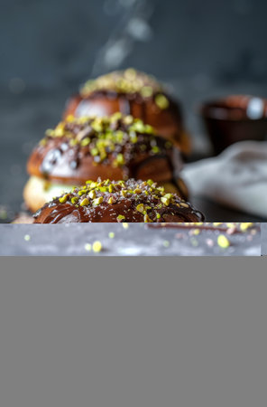 Three donuts are shown covered in chocolate and colorful sprinkles, looking delicious and tempting. The donuts are placed on a clean white plate, showing their sweet and indulgent appearance.の素材