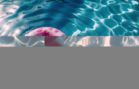 A red and white life preserver is seen floating on the surface of a pool of clear blue water. The circular buoyant device provides safety in case of emergencies.の素材