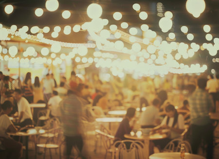 A diverse group of individuals are seated at tables inside a bustling restaurant, engaged in conversations and enjoying their meals.の素材