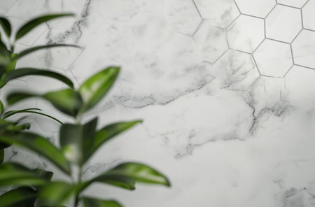 Three white vases containing plants sit on a marble wall next to a lush green plant, creating a simple yet elegant display.の素材