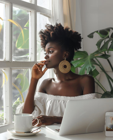 A woman is sitting in front of a laptop computer, working or studying intently.の素材