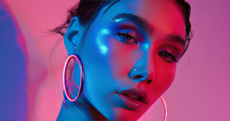 A woman with vibrant neon makeup and oversized hoop earrings standing confidently.の素材