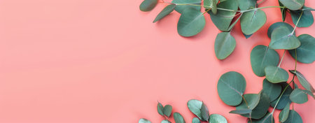 A plant with vibrant green leaves stands out against a soft pink background, creating a striking color contrast.の素材