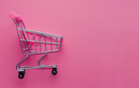 A shopping cart placed on a vibrant pink background, creating a colorful contrast.の素材