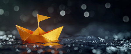 A yellow origami boat peacefully floats on the calm water surface.の素材