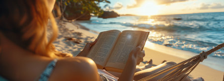 A woman relaxes in a hammock on a beach, reading a book as the sun sets over the ocean.の素材
