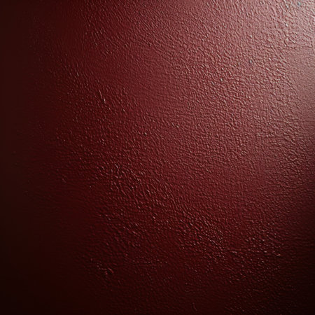 A close-up shot of a deep red textured wall with a soft light shining from the top.の素材