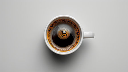 A cup filled with black liquid, likely coffee, resting on a surface.の素材