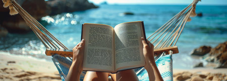 A woman relaxes in a hammock on a beach, reading a book as the sun sets over the ocean.の素材
