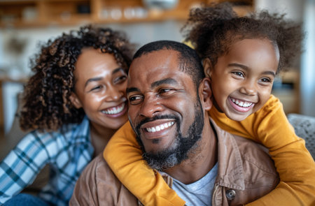 A father and his two daughters are smiling and hugging in a cafe. The family is enjoying their time together and is full of love.の素材