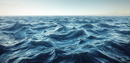 The blue ocean waves gently roll under a clear, blue sky with fluffy white clouds.の素材