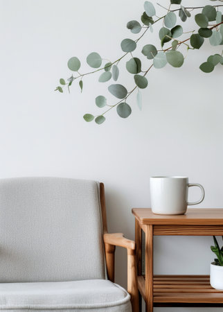 A wooden desk with a laptop on top and a gray chair sits in front of a wall, with a potted plant to the left and a hanging plant to the right.の素材