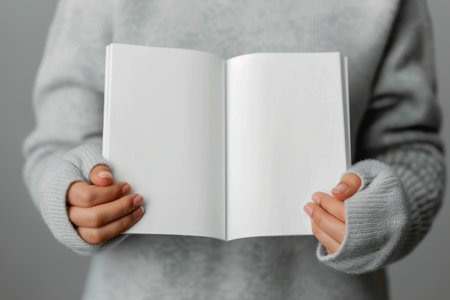 A close-up of an open book resting on a table, the pages fanned out to reveal the text printed within.の素材