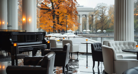 A rainy day view from a lounge, featuring a black piano, two tables, and a comfortable couch. Flowers in a vase decorate one table. The window view is of a large tree with orange leaves, and the ground is wet and glistening.の素材