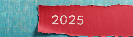 A vibrant red section of paper peels away to reveal the year 2025, set against a textured blue wall. The contrast creates an eye-catching visual, suggesting change or anticipation for what lies ahead.の素材