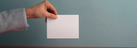 A businessman in a suit examines a document closely, focusing on the details while seated at a contemporary desk in a brightly lit office. The background is blurred, highlighting his engaged posture.の素材