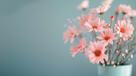 Soft pink bloom flowers gracefully, showcasing their delicate petals against a serene blue backdrop, evoking the beauty of springtime.の素材