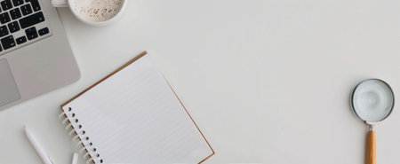 An open notebook lies on a tabletop accompanied by a magnifying glass, an orange pen, a cup of coffee, and a small succulent plant, creating a cozy workspace for writing and reflecting.の素材