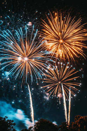 Brilliant bursts of red, blue, green, and gold fireworks illuminate the dark sky, creating a vibrant celebration atmosphere enjoyed by spectators gathered below.の素材