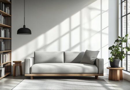 A sleek gray sofa is positioned in a well-lit living room, complemented by a cozy plant and wooden furniture. The sunlight casts intricate shadows on the wall, creating a warm atmosphere.の素材