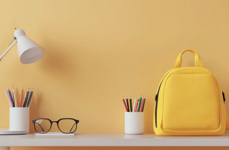 A study area features a bright yellow bag, glasses, and colorful pencils in white holders on a simple desk. The walls are painted in a vibrant yellow, creating an inviting space.の素材