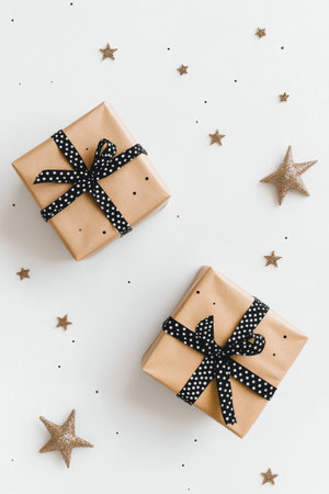 Elegant gifts wrapped in polka dot paper sit on a white surface, surrounded by shiny gold stars, perfect for a celebration or holiday.の素材