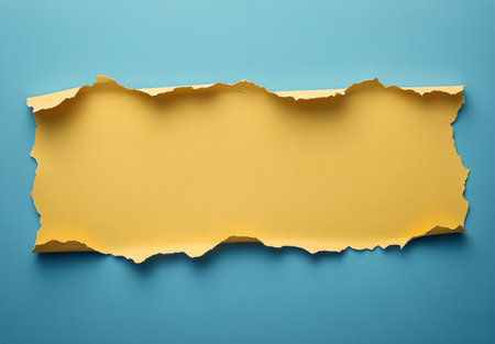 A piece of torn yellow paper is placed on a textured blue background, showing a striking contrast that is perfect for creative projects or artistic displays.の素材