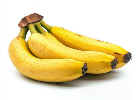 A cluster of fresh yellow bananas rests side by side on a smooth white surface, highlighting their vibrant color and appealing shape. The arrangement showcases their natural beauty.の素材