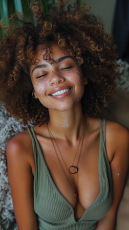 A woman with curly hair is smiling while wearing a tank top.の素材