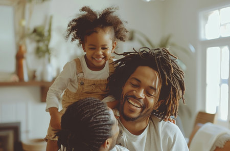 A father laughs with his children at home.の素材