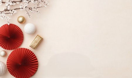 Red paper fans and white ornaments are artfully arranged alongside cherry blossom branches on a soft background. This setup enhances the festive atmosphere for a celebratory event.の素材