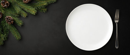 A white plate sits empty on a black table, surrounded by fresh pine branches and small pine cones. This arrangement creates a festive and elegant atmosphere for seasonal dining.の素材
